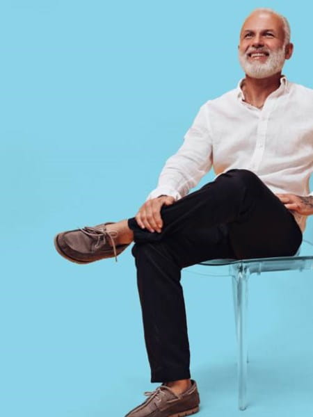 Smiling man in white shirt sitting on a chair