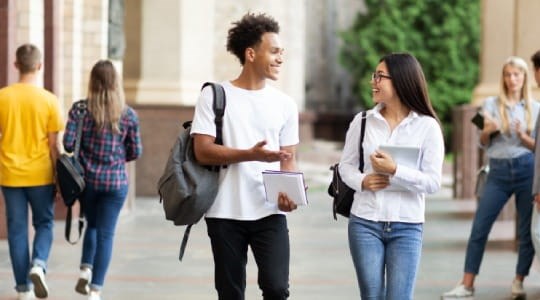 Two college students talking as they leave class