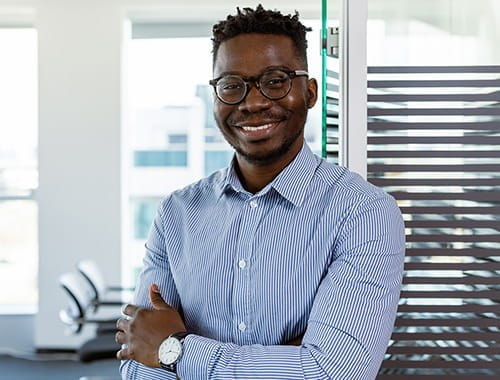 young man wearing glasses smiling blue shirt office employee