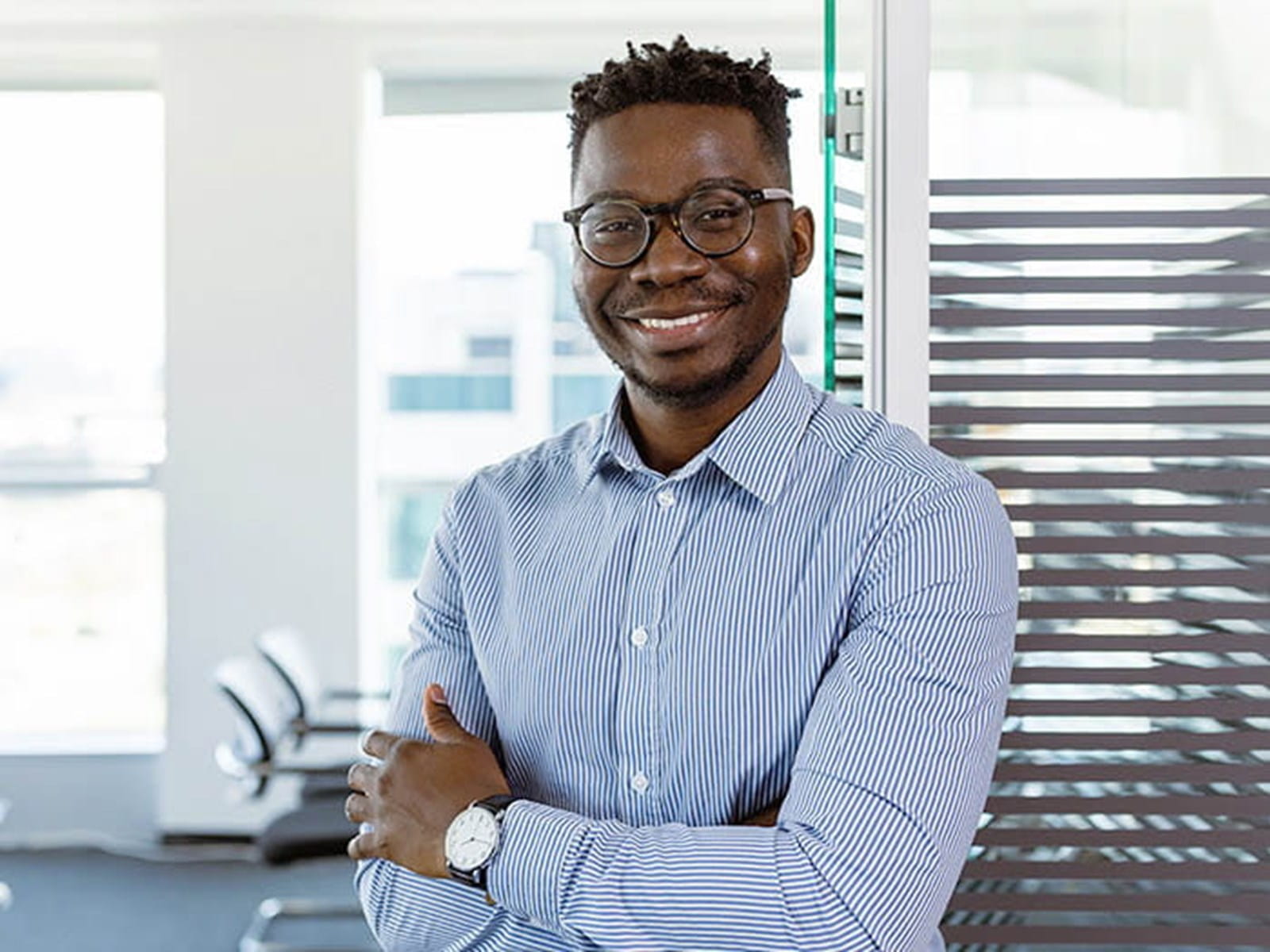 young man wearing glasses smiling blue shirt office employee