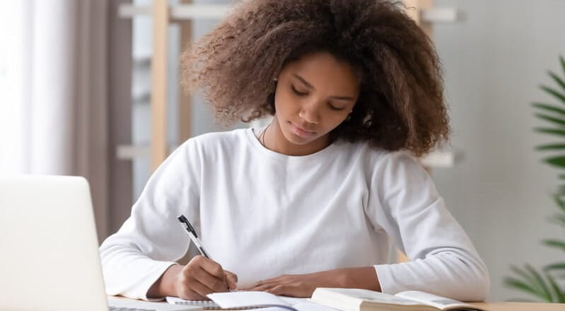 Student studying with books and laptop