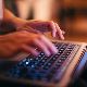 An photograph of hands typing on a laptop keyboard