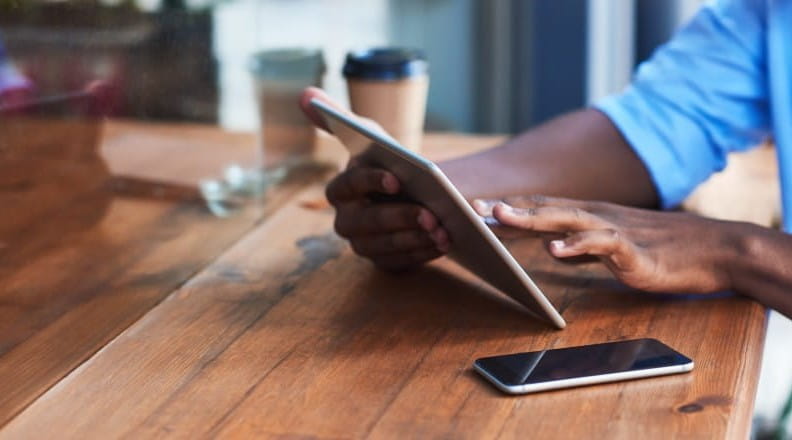 Someone's hand holding a tablet and browsing