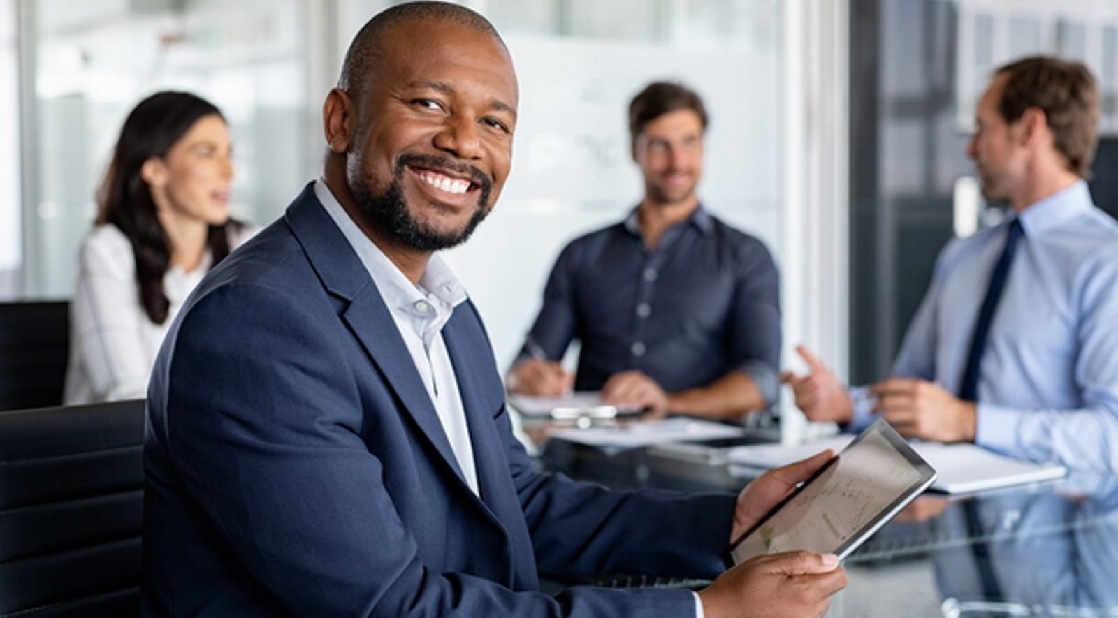Businessman holding tablet and smiling.