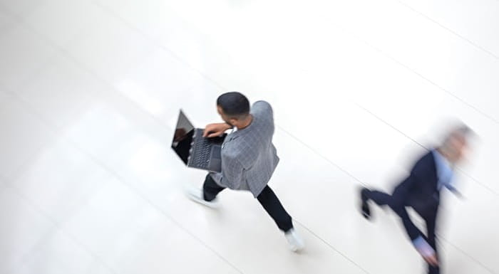 Aerial view of man on laptop walking through concorce