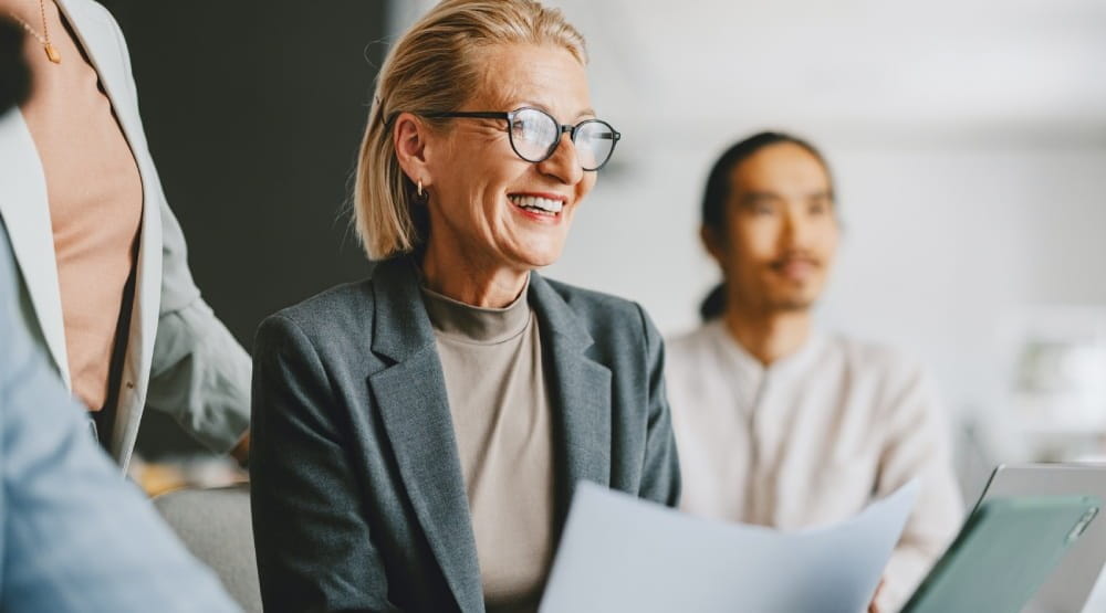 Woman wearing glasses holding a report