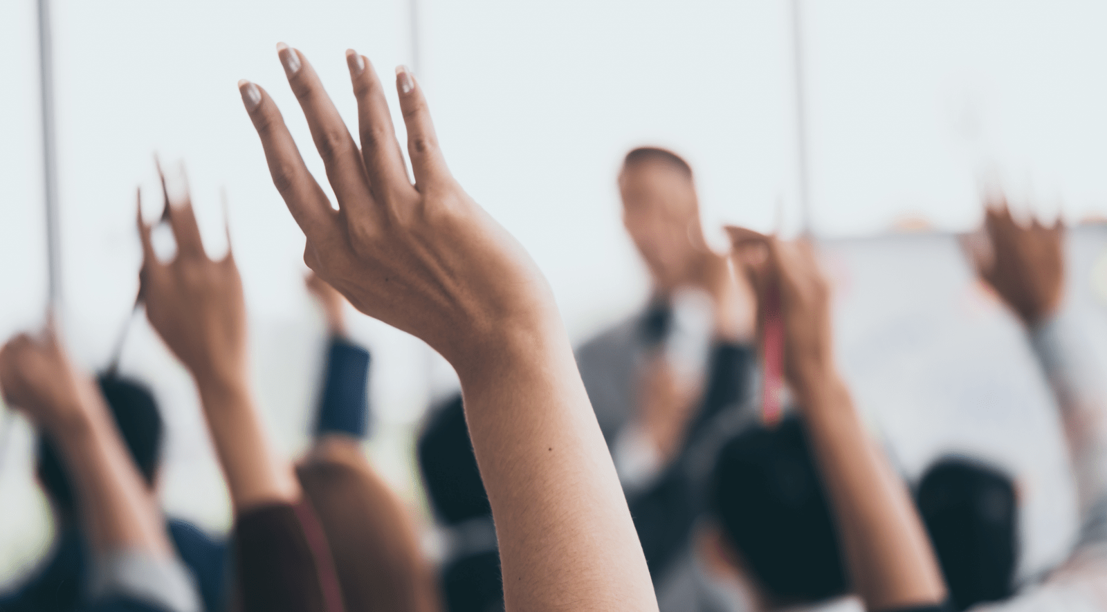 Close up of raided hands in a classroom setting