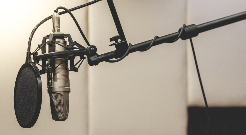 Microphone and pop filter symbolising recording a podcast